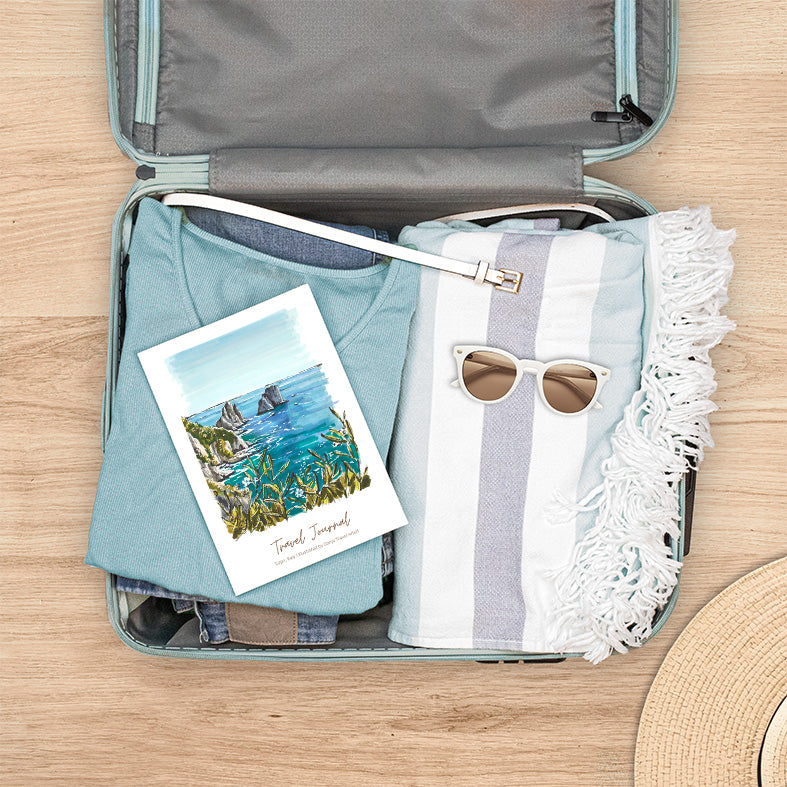 Reisetagebuch Italien mit handgezeichneter Illustration der Faraglioni-Felsen auf Capri, bereit für die Reise im Koffer
